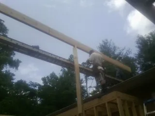 Carpenter setting a ridge beam over a new addition frame — Ice Dam Removal by Roofing Brothers in Shelburne Falls