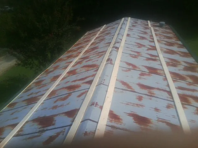 Rusted metal roof panels with new wood purlins before replacement — Storm Damage Roof Repair in Shelburne Falls by Roofing Brothers