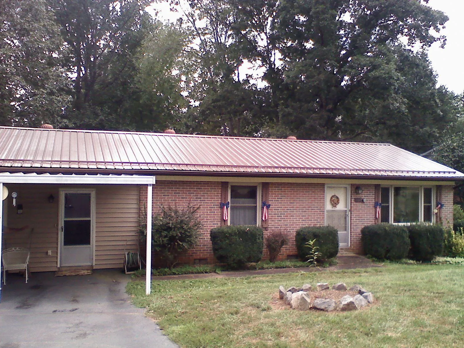 Bronze metal roof and carport on a brick ranch home — Roof Repair work by our crew in Shelburne Falls